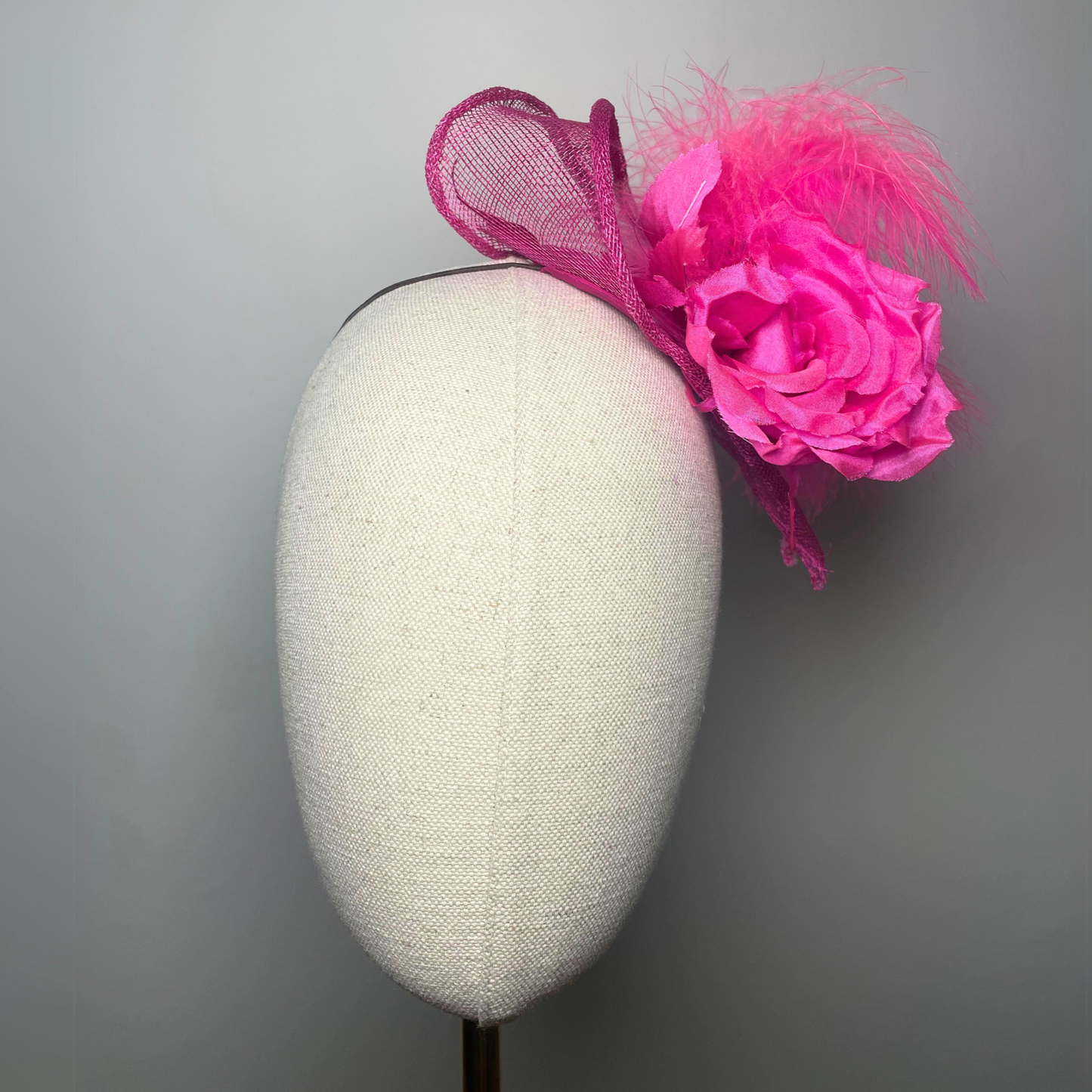 Fuchsia pink flower, feather fascinator.
