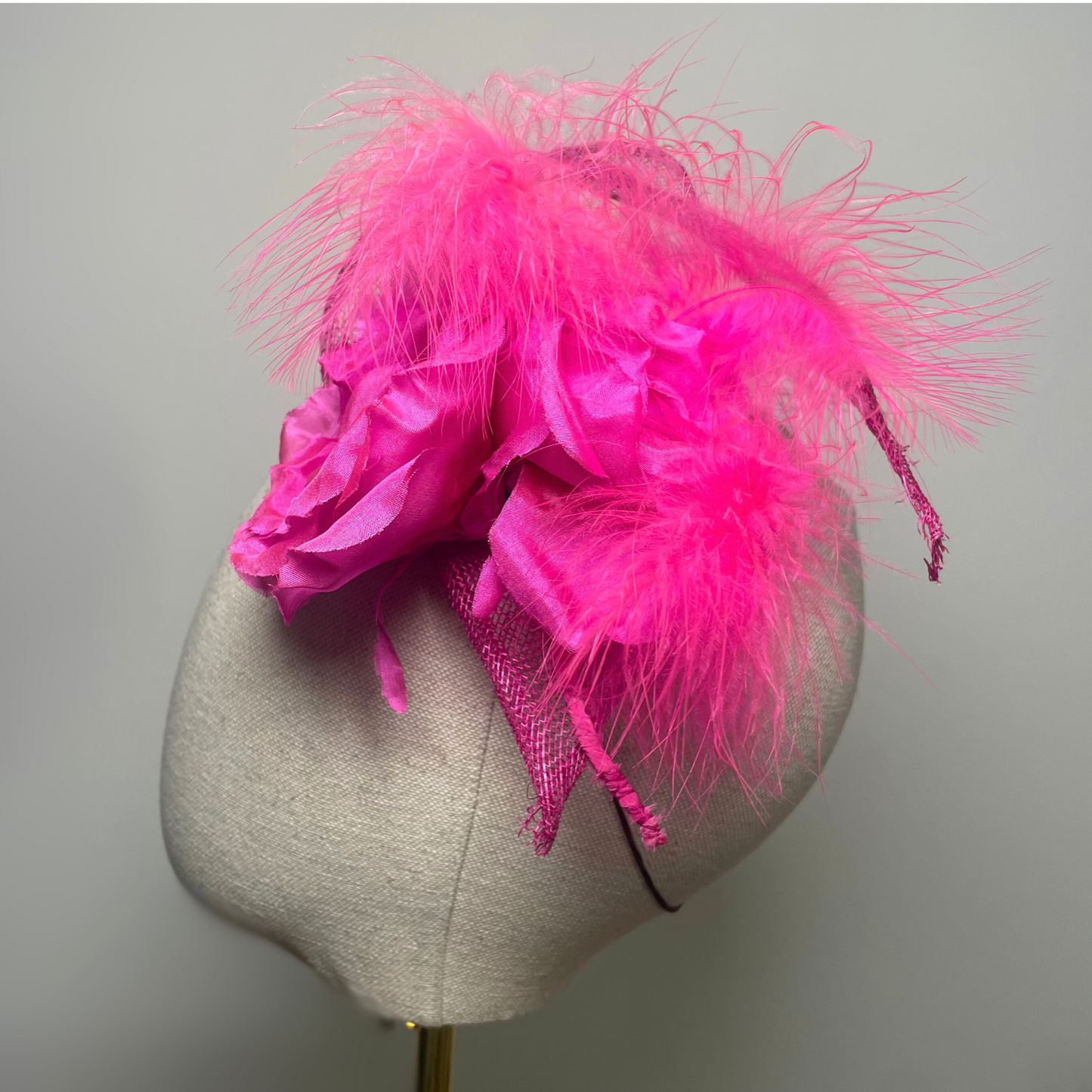 Fuchsia pink flower, feather fascinator.