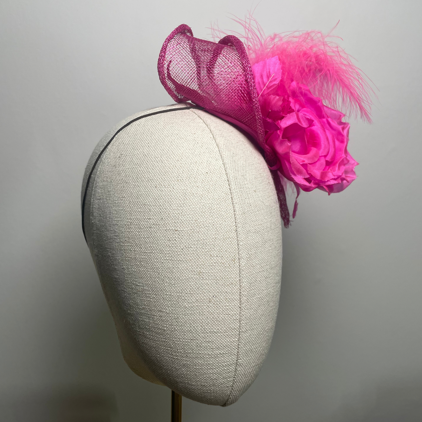 Fuchsia pink flower, feather fascinator.