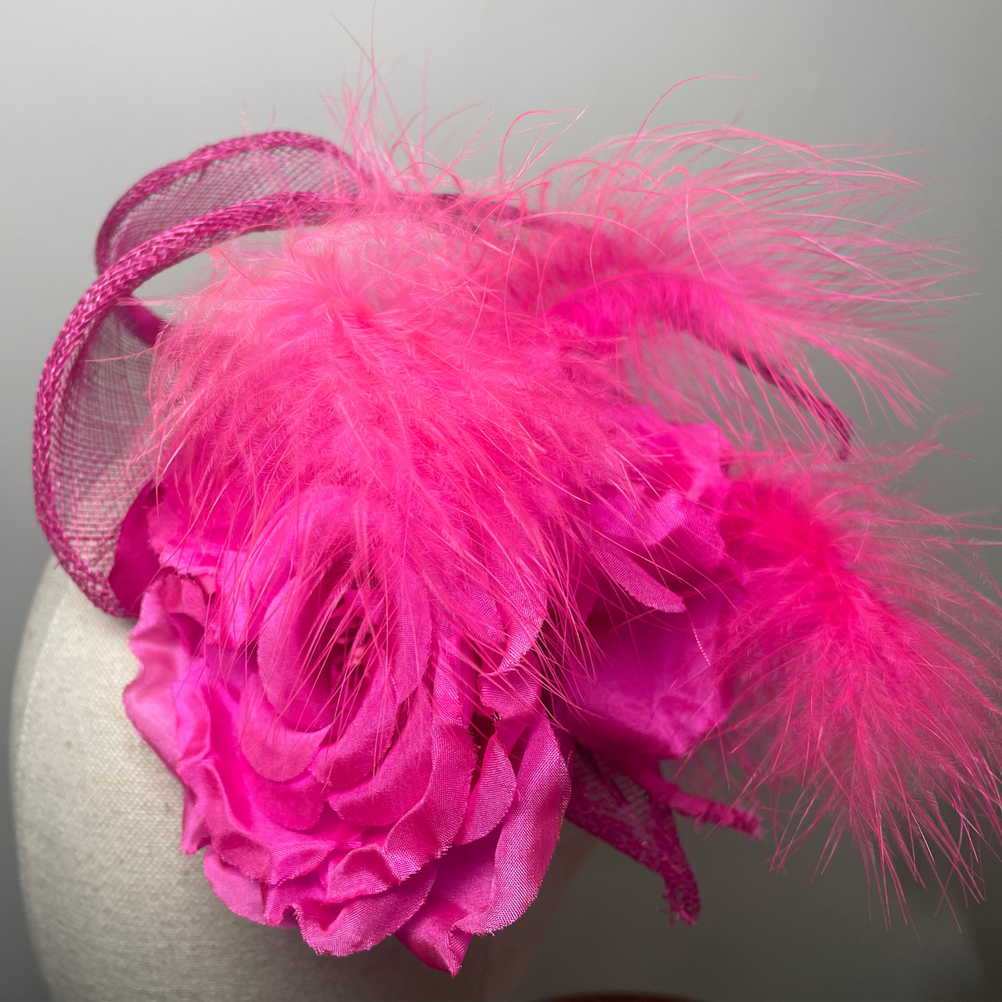 Fuchsia pink flower, feather fascinator.