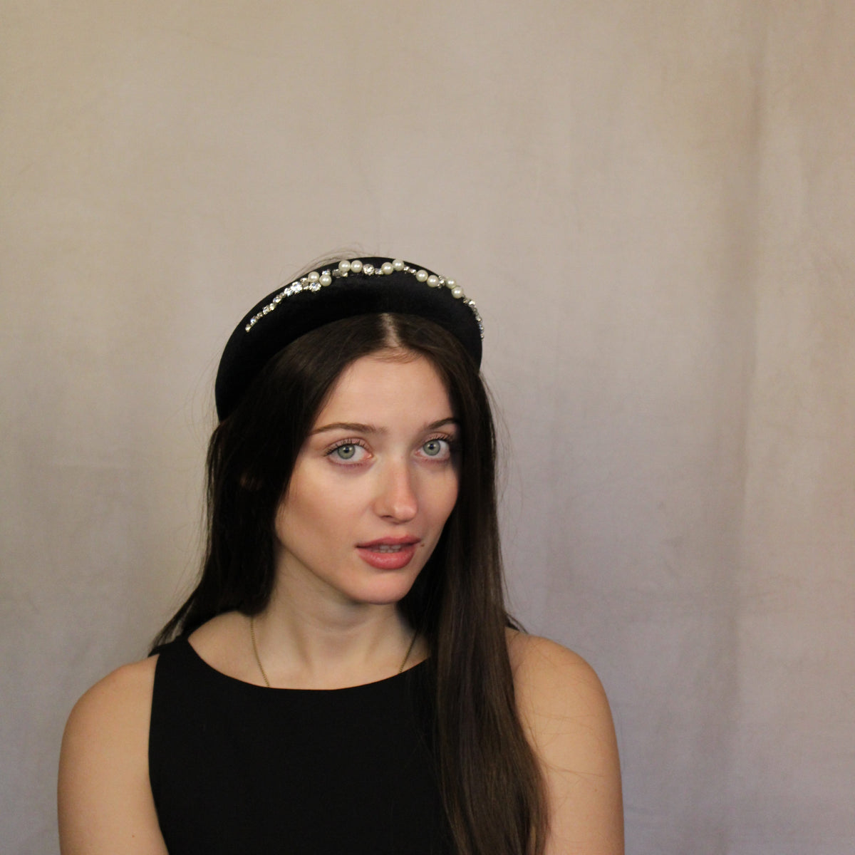 A woman wearing a black velour headband with diamanté embellishments.