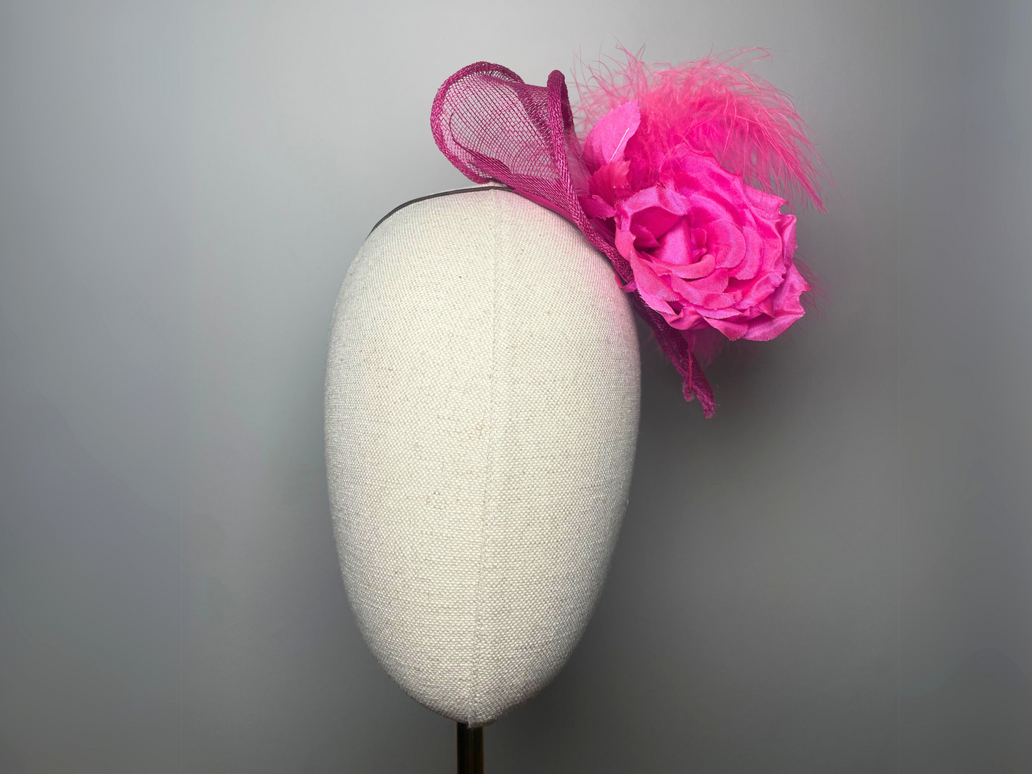 Fuchsia pink flower, feather fascinator.