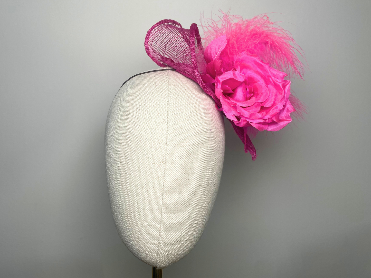 Fuchsia pink flower, feather fascinator.