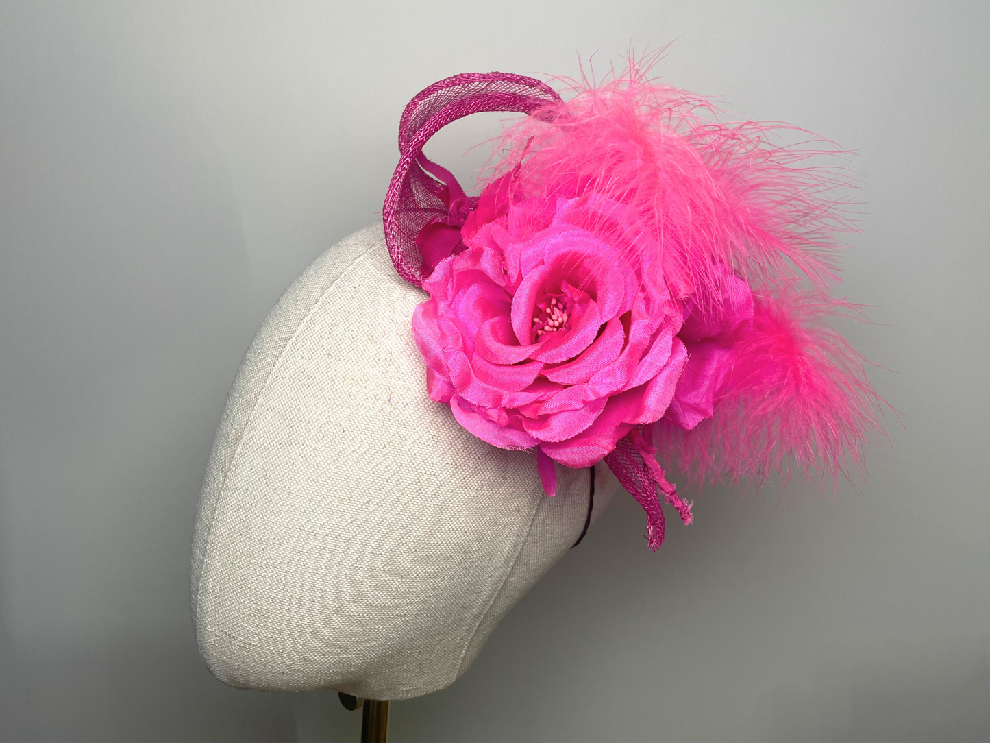 Fuchsia pink flower, feather fascinator.