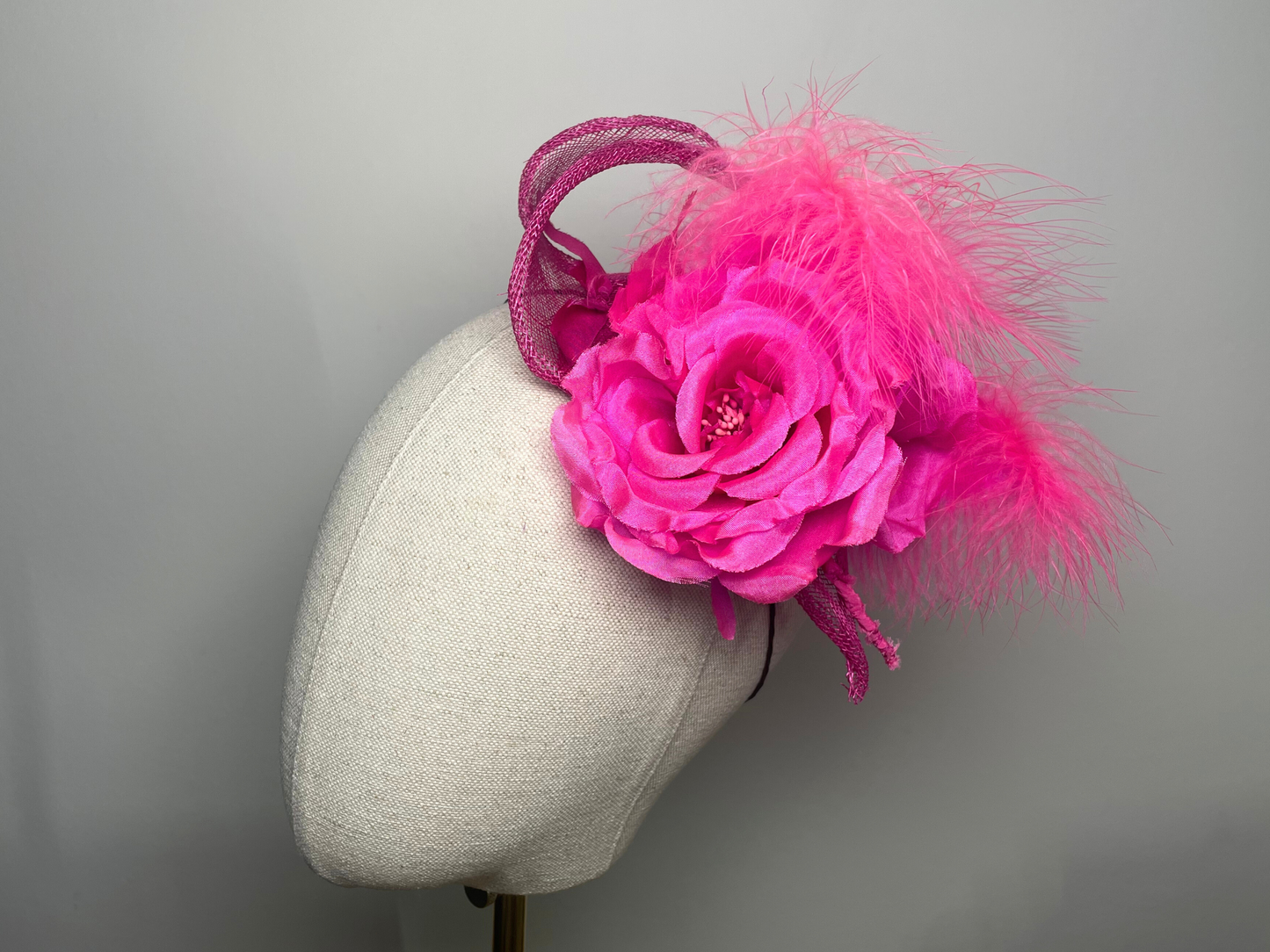 Fuchsia pink flower, feather fascinator.