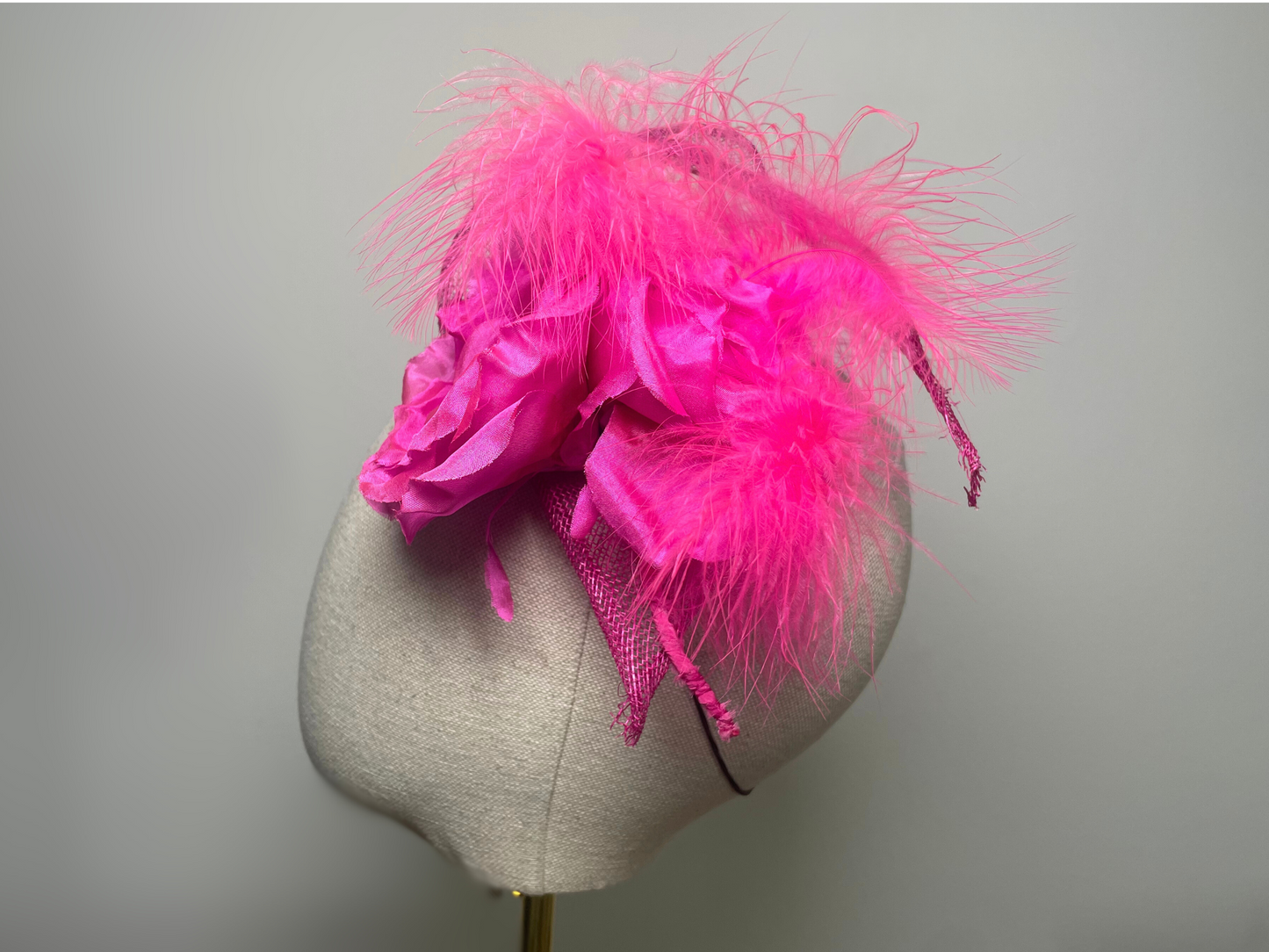 Fuchsia pink flower, feather fascinator.