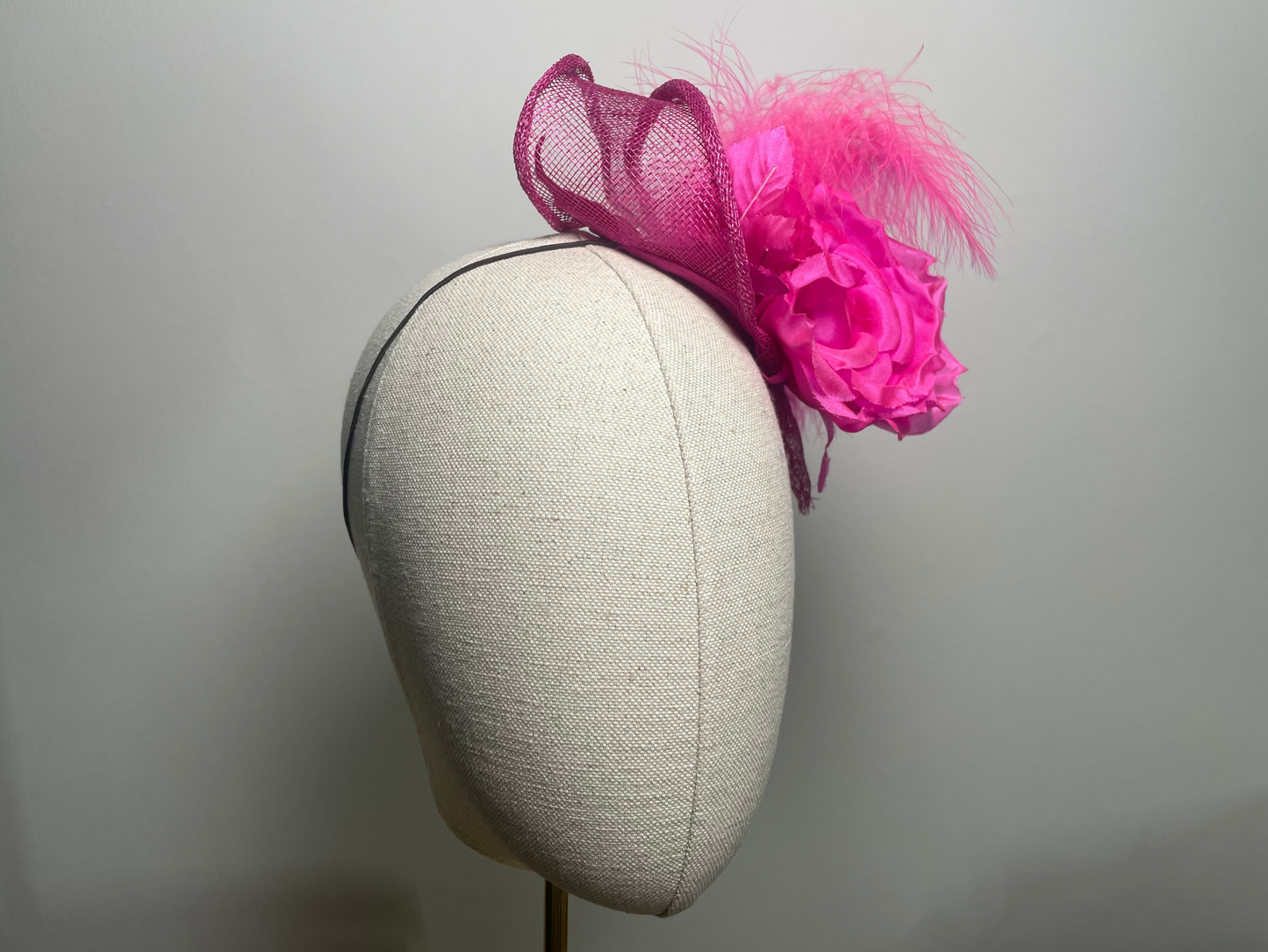 Fuchsia pink flower, feather fascinator.