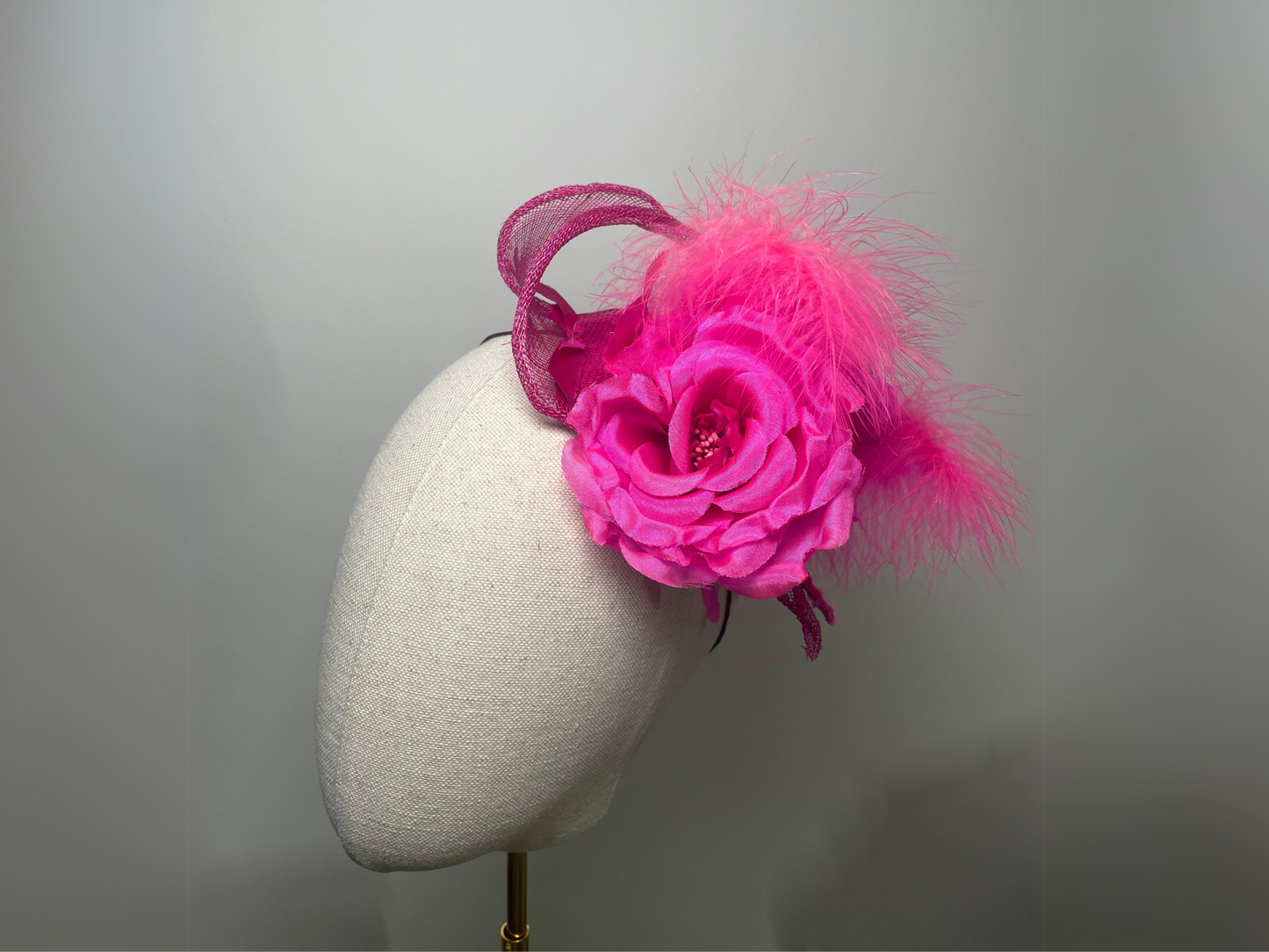 Fuchsia pink flower, feather fascinator.