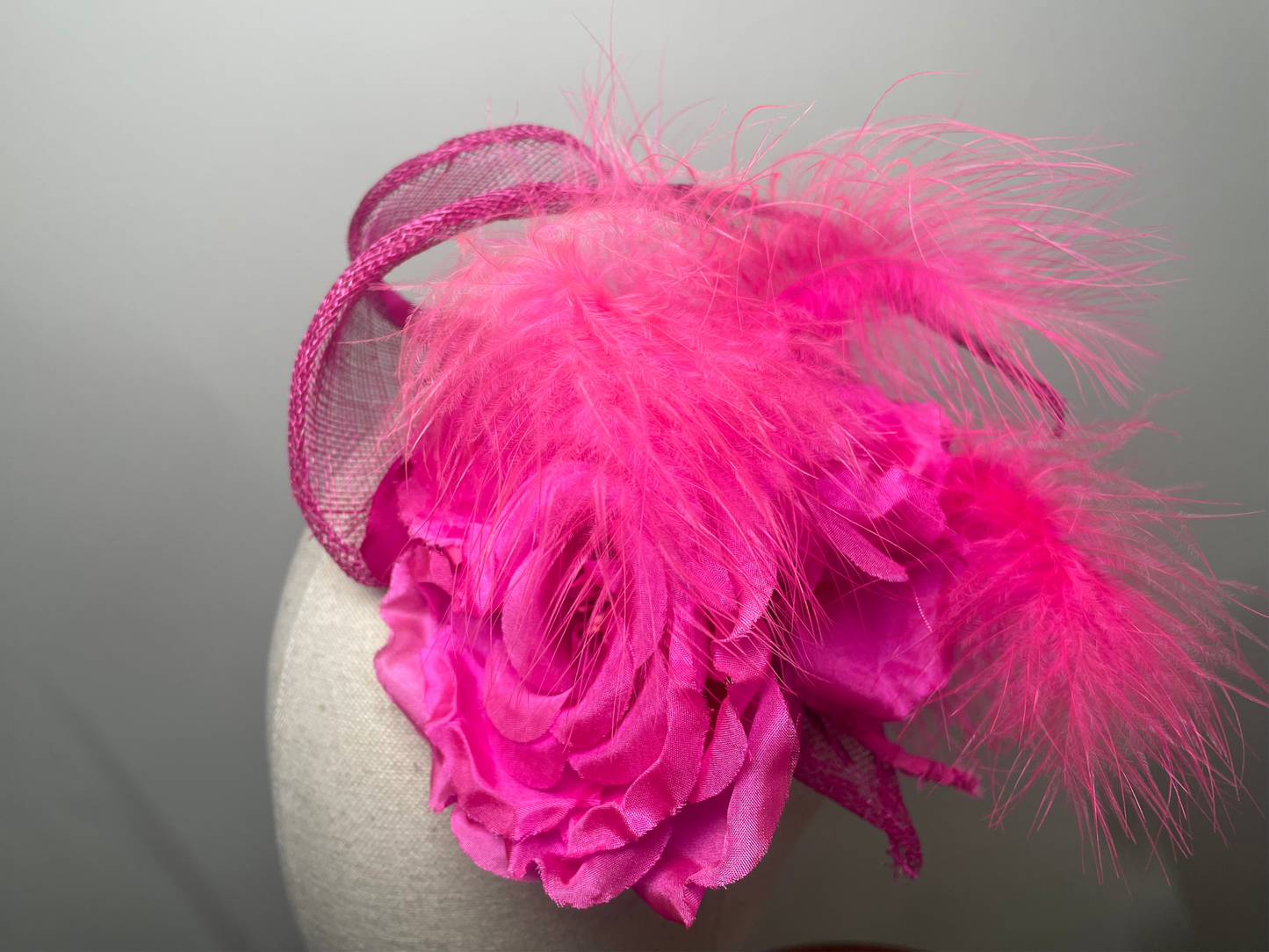 Fuchsia pink flower, feather fascinator.